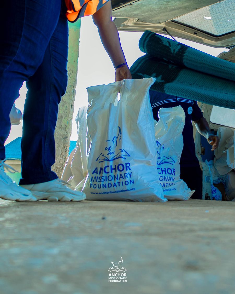 Close-up of an Anchor Missionary Foundation relief bag being loaded for distribution
