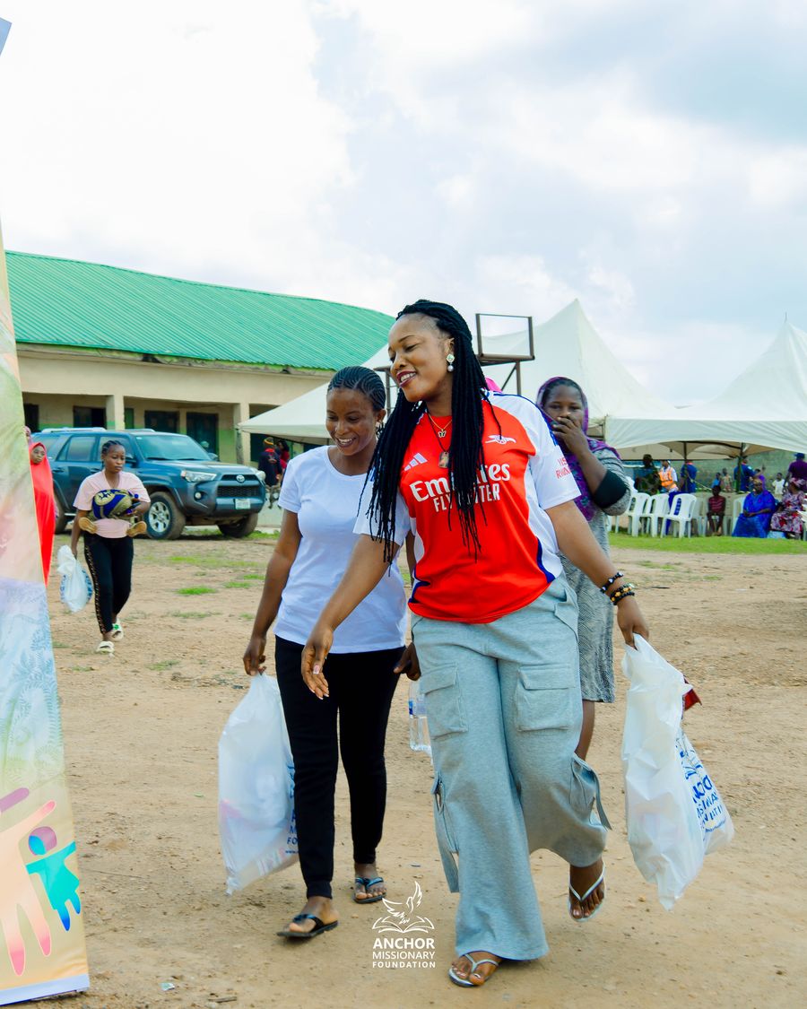 Volunteers walking with Anchor Missionary Foundation relief bags at a community outreach