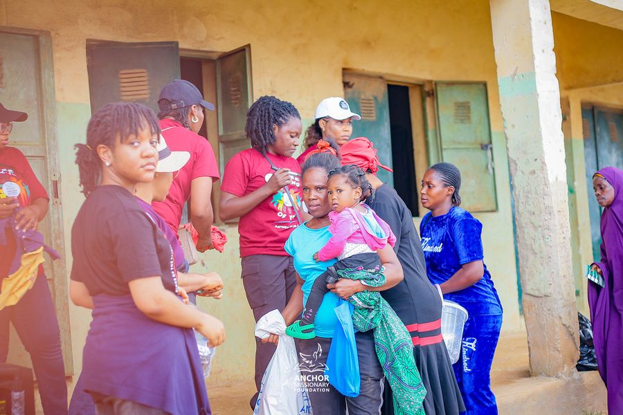 A mother carrying her child through a community outreach event